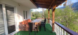 un balcón de una casa con mesa y sillas en Vlasic holiday home en Vlasic