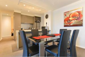 a dining room and kitchen with a table and chairs at StayCentral - Cityviews on City Road Southbank in Melbourne