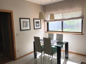 a dining room with a table with chairs and a window at Casa do Pereiro in Vieira do Minho