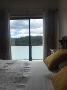 una camera da letto con una grande finestra con vista sull'acqua di Casa do Pereiro a Vieira do Minho Altre 42 foto