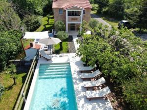an aerial view of a swimming pool with chairs and a house at Wellness House Oliva, Heated Pool, Sauna and Jacuzzi in Labin +60 photos