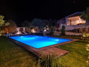 a swimming pool in a backyard at night at Alaçatı Beka House in Alacati