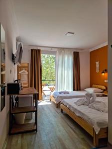 a hotel room with two beds and a window at Alaçatı Beka House in Alaçatı