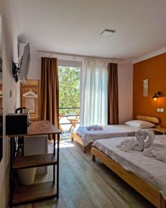 a hotel room with two beds and a window at Alaçatı Beka House in Alaçatı