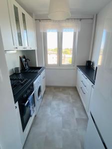 a kitchen with a stove and a washer and dryer at Apartament Długie Ogrody 54 in Gdańsk