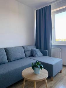a blue couch in a living room with a table at Apartament Długie Ogrody 54 in Gdańsk