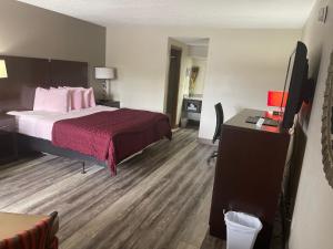 Habitación de hotel con cama y escritorio en Royal Inn & Suites, en Mountain Grove