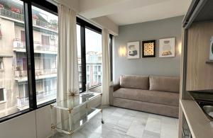 a living room with a couch and some windows at MELMA PROPERTIES - ARIA-Piraeus Central Penthouse in Piraeus
