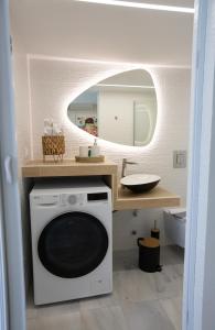 uma máquina de lavar roupa na casa de banho com um espelho em MELMA PROPERTIES - ARIA-Piraeus Central Penthouse em Pireu