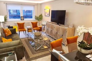 sala de estar con sofá y TV en 39 steps to Harrods 2 Beds with AC en Londres
