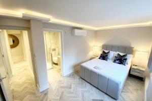 a bedroom with a white bed and a bathroom at 39 steps to Harrods 2 Beds with AC in London