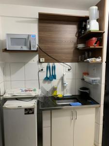 a small kitchen with a sink and a microwave at Apartamento Paim in São Paulo