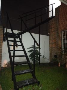 einem Metalletagenbett vor einem Gebäude in der Unterkunft Casa Ana, departamento amplio a 20 ' aeropuerto in Luis Guillón