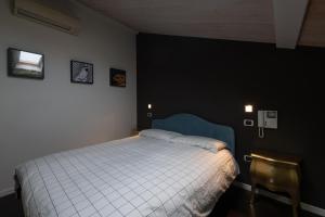 una camera da letto con un letto bianco e una sedia di La Casa di Angelina - Pesaro Centro-Mare a Pesaro