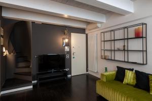 un soggiorno con divano giallo e TV di La Casa di Angelina - Pesaro Centro-Mare a Pesaro