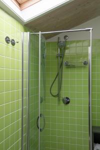 La salle de bains est pourvue d'une douche et de carrelage vert. dans l'établissement Casa Angelina Pesaro Centro Mare, à Pesaro