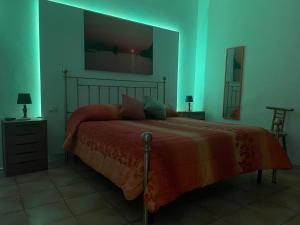1 dormitorio con 1 cama con luz verde en Appartamento ROSA en Lipari