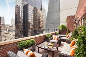 a rooftop patio with couches and tables on a building at Omni Berkshire Place in New York