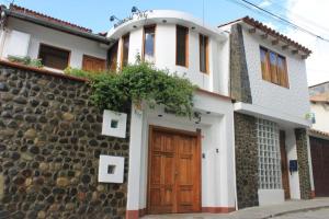 a house with a stone wall and a wooden door at Andean Hostel in Huaraz