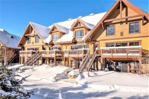 a large log home with snow on the ground at Étoile Du Matin 1510-19/Perfect for large Family in Mont-Tremblant