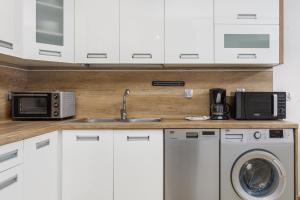 a kitchen with a sink and a microwave at Apartament Osiedle Bursztynowe Bałtycka by Renters in Kołobrzeg