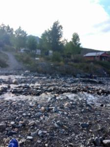 una persona parada en un suelo rocoso con un río en LC House en Potrerillos