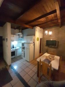 a kitchen with a table and a white refrigerator at El Destino Casa de Descanso in Tandil