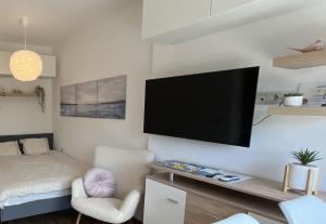 sala de estar con TV de pantalla plana en la pared en Lila Apartman, en Balatonföldvár