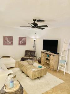 a living room with a couch and a flat screen tv at Sanctuary Home Naples-Private Pool and Lanai! in Naples