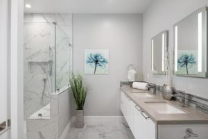 ein weißes Bad mit 2 Waschbecken und einer Dusche in der Unterkunft 645 Fresh Modern Condo Inside Resort Gates - Free Wifi - Walk to Spa in Encinitas + 11 Fotos