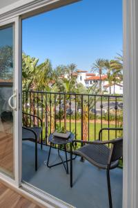 eine Terrasse mit zwei Stühlen und einem Tisch auf einem Balkon in der Unterkunft 645 Fresh Modern Condo Inside Resort Gates - Free Wifi - Walk to Spa in Encinitas
