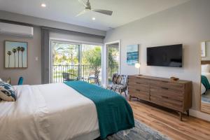 Schlafzimmer mit einem Bett, einem TV und einem Balkon in der Unterkunft 645 Fresh Modern Condo Inside Resort Gates - Free Wifi - Walk to Spa in Encinitas