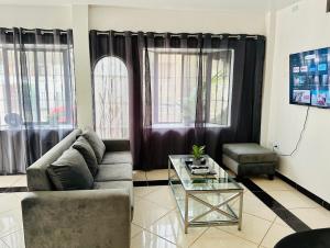 a living room with a couch and a glass table at Comfortable 3-Bedroom Condo in Bellavista, Guayaquil in Guayaquil