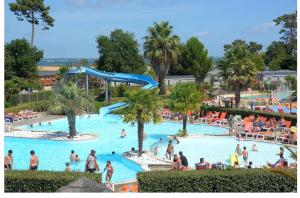 a group of people in a pool at a resort at Mobil home 3 chb tout confort, Espace Enfants - Claouey Cap Ferret in Lège-Cap-Ferret