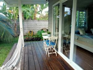 a porch with a bed and a table and chairs at Mataiarii lodge in Papara