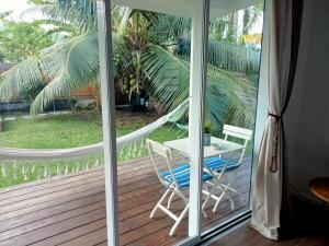 a sliding glass door with a table and chairs on a deck at Mataiarii lodge in Papara