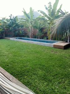 a backyard with a lawn and a swimming pool at Mataiarii lodge in Papara