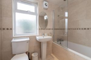 y baño con aseo, lavabo y ducha. en Fully Equipped 4 Bedroom House with large Garden, en Hendon