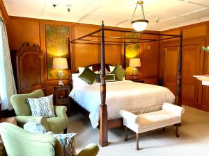 a bedroom with a bed and two chairs at The Latch Inn in Sidney