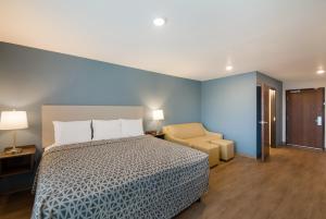 a bedroom with a bed and a chair at WoodSpring Suites Austin Central in Austin