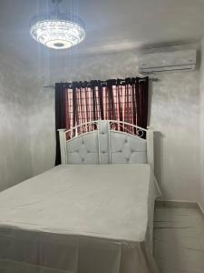 a bed in a room with a window at Residencial Palma Real (4to Nivel) in Santiago de los Caballeros