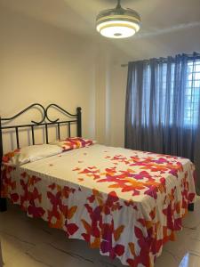 Un dormitorio con una cama con una manta de flores. en Residencial Palma Real (4to Nivel) en Santiago de los Caballeros