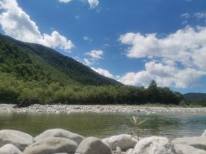 a river with rocks in front of a mountain at Apartment river Nadiža Podbela in Podbela