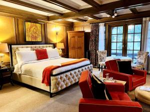 a bedroom with a large bed and a red chair at The Latch Inn in Sidney