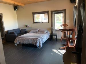a bedroom with a bed and a couch and a table at Les terrasses st aimé in Saint Aime Des Lacs