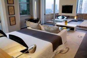 a bedroom with a large bed and a living room at Sheraton São Paulo WTC Hotel in Sao Paulo