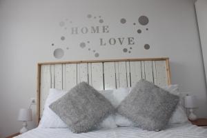 uma cama com duas almofadas e um cartaz que diz amor caseiro em El Racó de Yleth em Deltebre