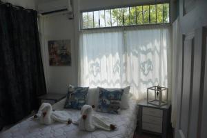 ein Schlafzimmer mit Schwänen auf einem Bett mit Fenster in der Unterkunft Spacious and relaxing property. in Ojochal