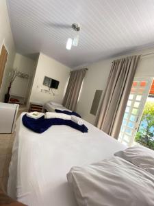 sypialnia z 2 białymi łóżkami i oknem w obiekcie Mambaí Inn w mieście Mambaí