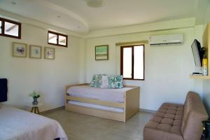 um quarto com uma cama, um sofá e janelas em CASA PUNTA CARNERO em Presidente Tamayo